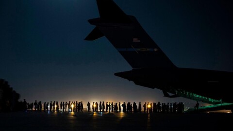 停机坪上的难民排队的照片登上飞机离开阿富汗。