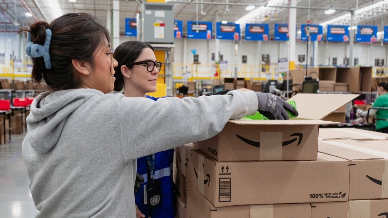 En un centro logístico están dos trabajadoras de Amazon organizando cajas. 