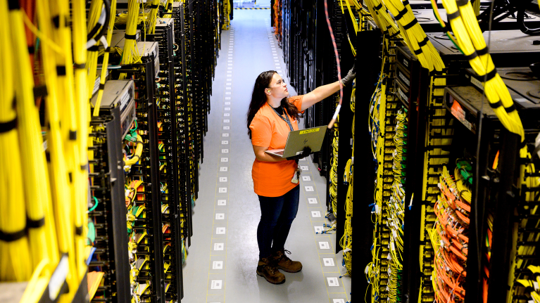 A technician inspecting wires inside a data center.