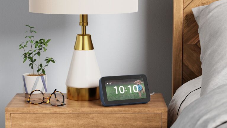 An image of the Amazon Echo 5 Show sitting on a nightstand with the time displayed.