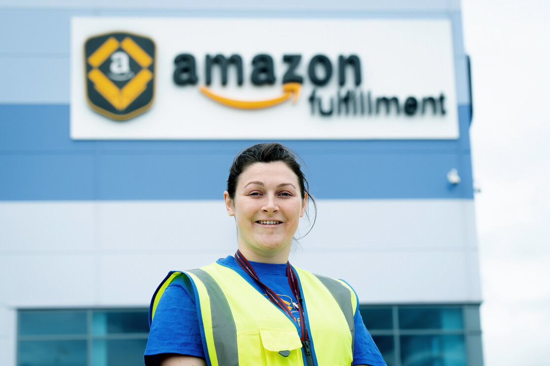 Sophie Martin smiling with a high visibility vest on, outside an Amazon fulfilment centre