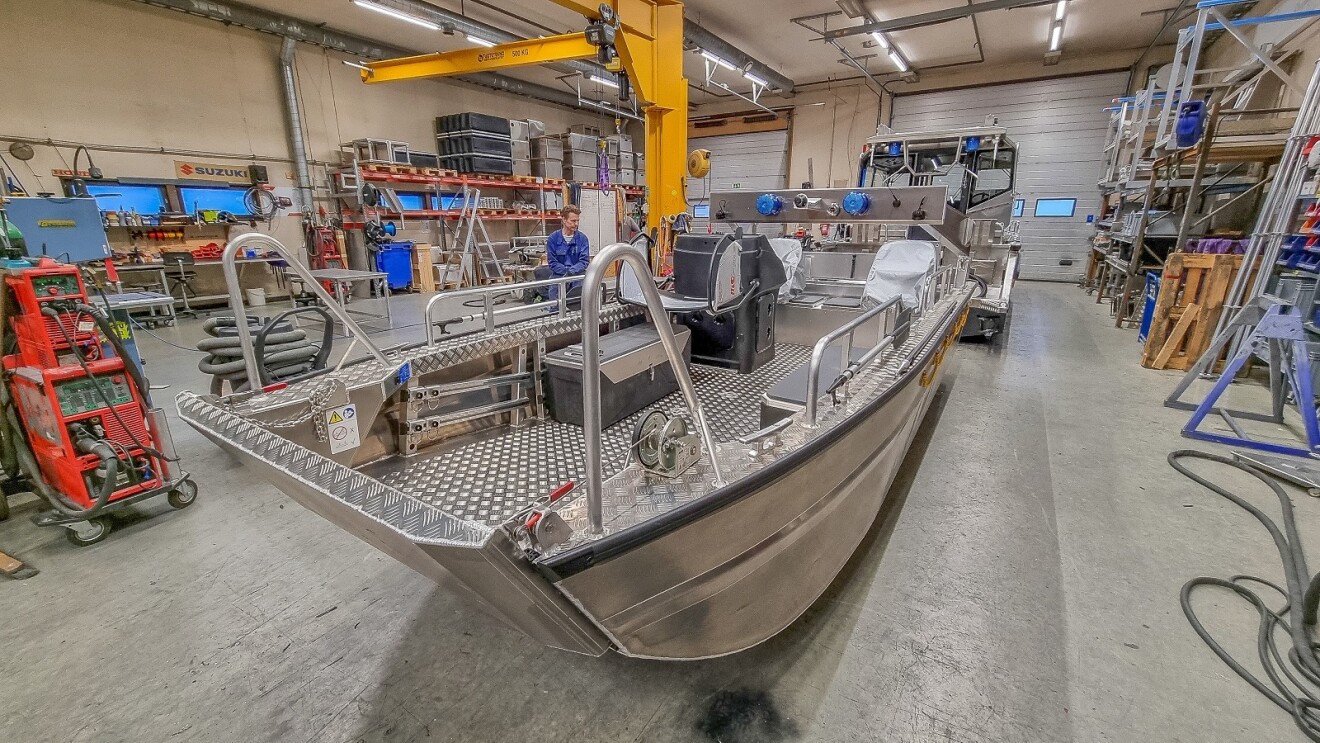 Ein unlackiertes Rettungsboot steht in der Halle einer Werft.