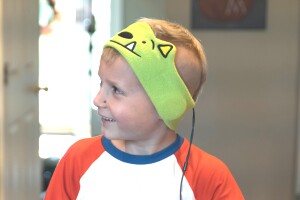 A smiling child wearing headband-style headphones.