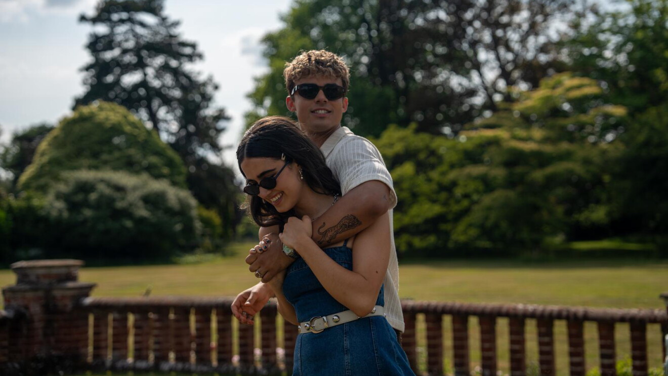 Young couple embracing outdoors in a park with trees in the background