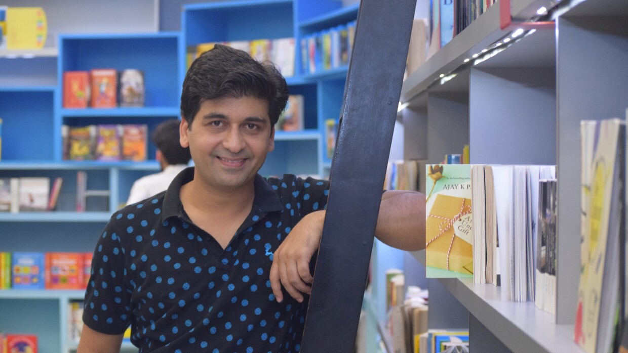 Ajay Pandey poses next to a book shelf