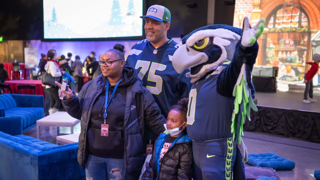 Amazon’s Winter Wonderland: three individuals standing next to mascot
