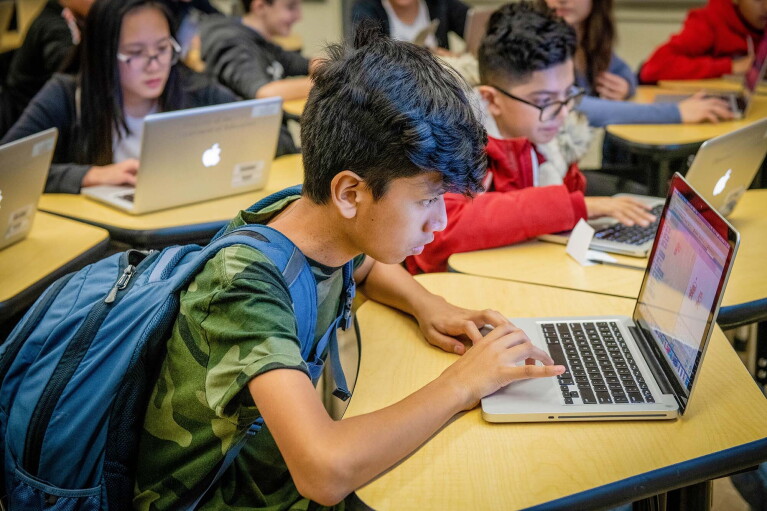 Students work on coding programs on laptop computers in a classroom at a New York City school. 