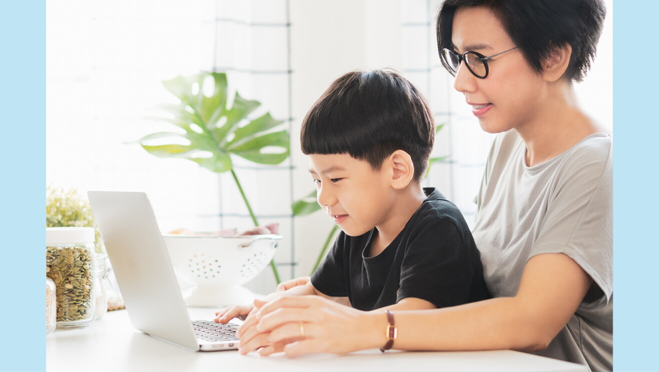 An image of a mother and a son looking at a laptop together.