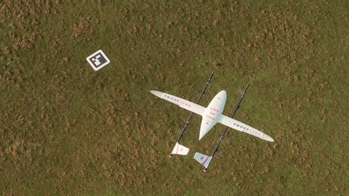 An areal photo of an autonomous drone making a medical delivery.