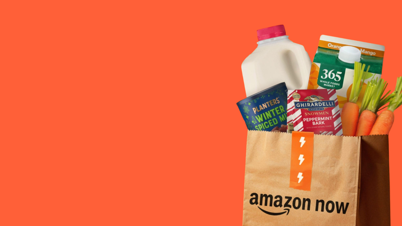 Amazon Now grocery delivery bag with various food items on orange background
