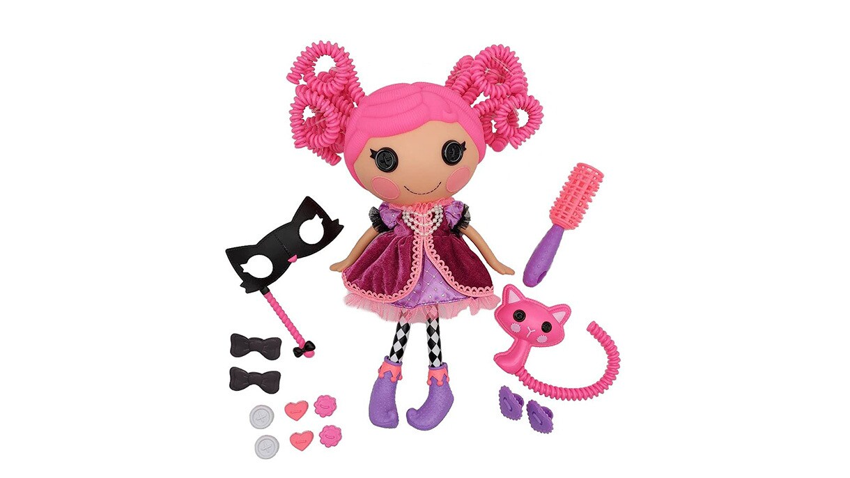 An image of a plush doll with pink hair and a purple dress and boots. There are accessories around the doll like a hair brush, and masquerade mask, bows, and a pink cat.