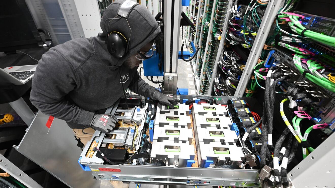 A data center technician working on a server rack.