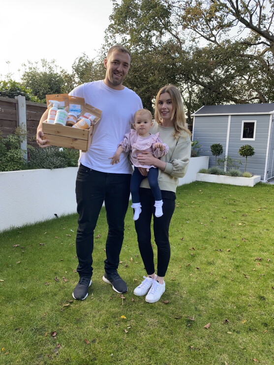 An image of Oliver and Evie Bristowe in their garden with their daughter and the Pets Purest Products. 