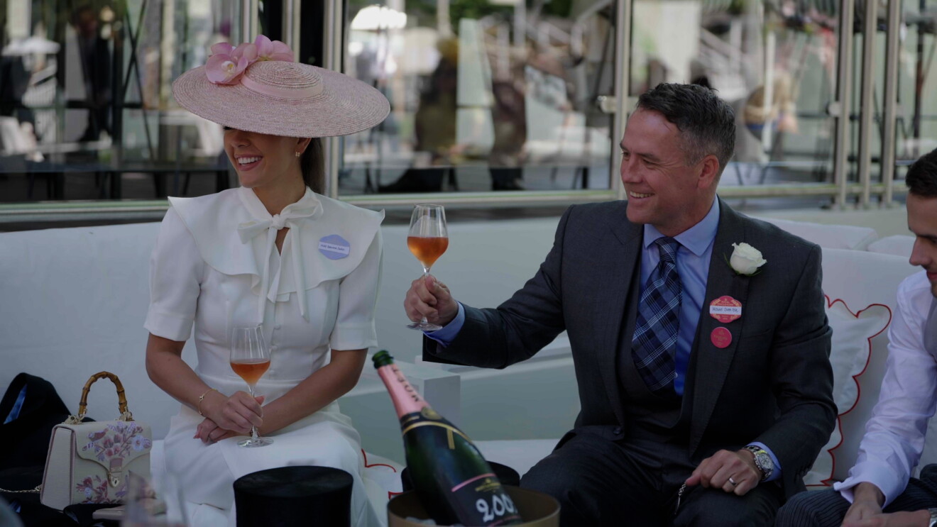 Michael Owen raises a glass at the races, sitting next to daughter Gemma