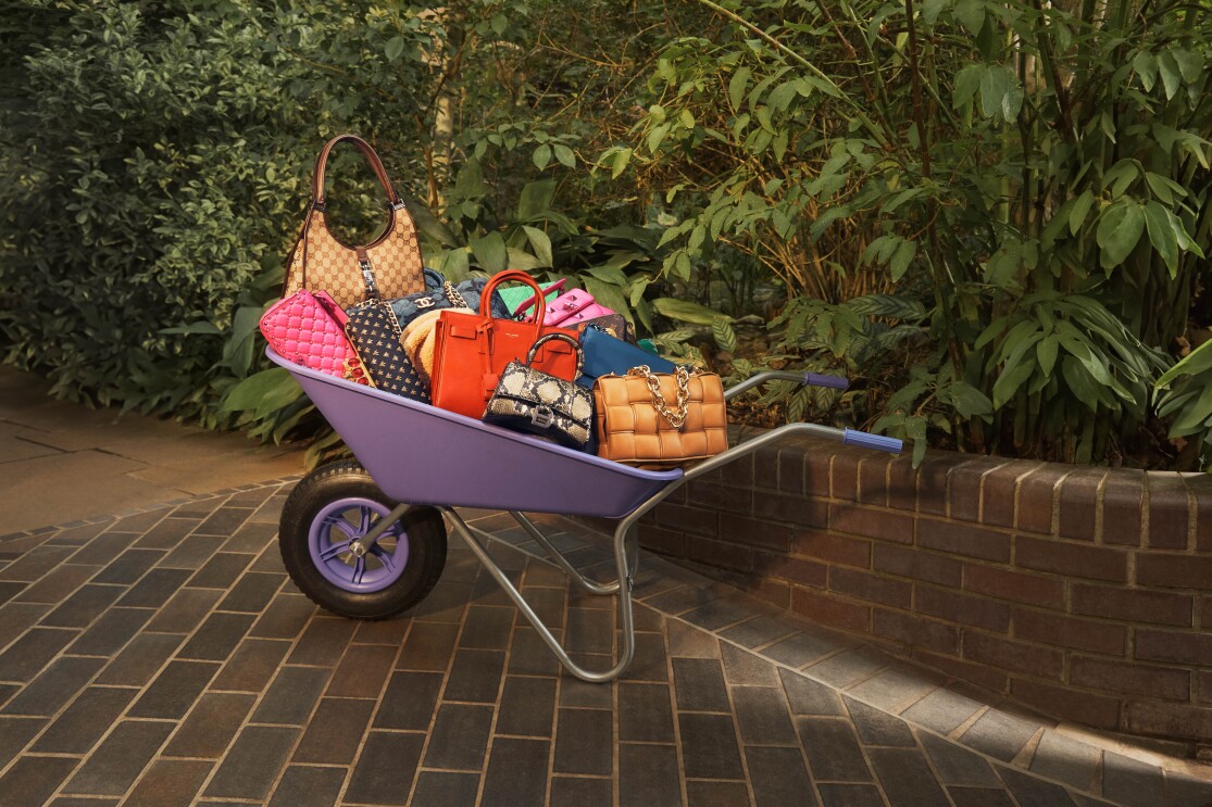 Colourful bags in a purple wheelbarrow in a green garden
