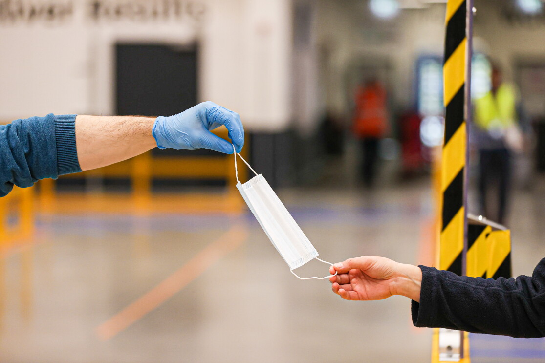 Während der Arbeit im Logistikzentrum trägt die Mitarbeiterin einen Mundschutz.