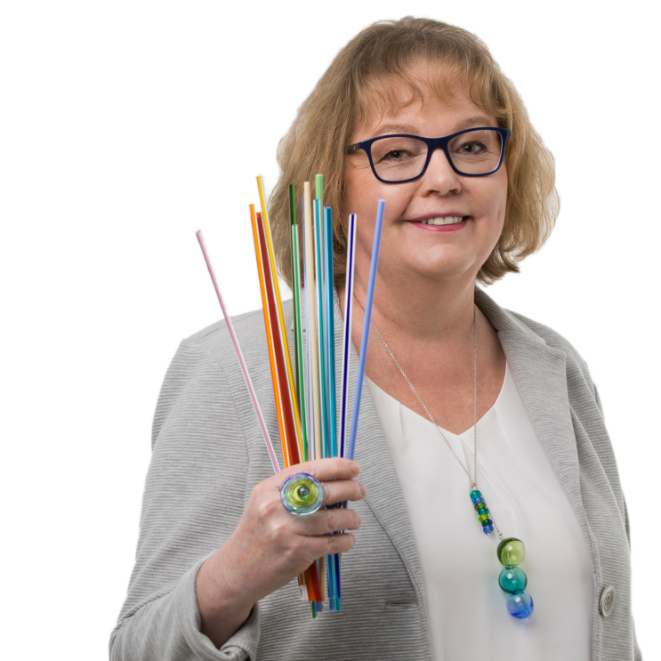 Eine Frau mit blonden Haaren und einer Brille lacht in die Kamera.