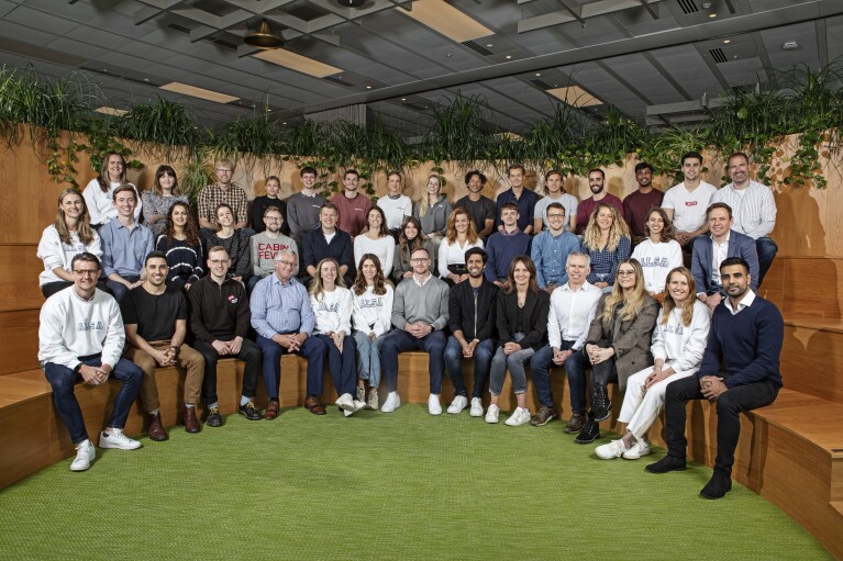 Gruppenfoto von allen Teilnehmern vom Amazon Sustainability Accelerator. Alle sitzen auf unterschiedlichen Ebenen im Kreis. Im Hintergrund sind Gras und Pflanzen erkennbar.