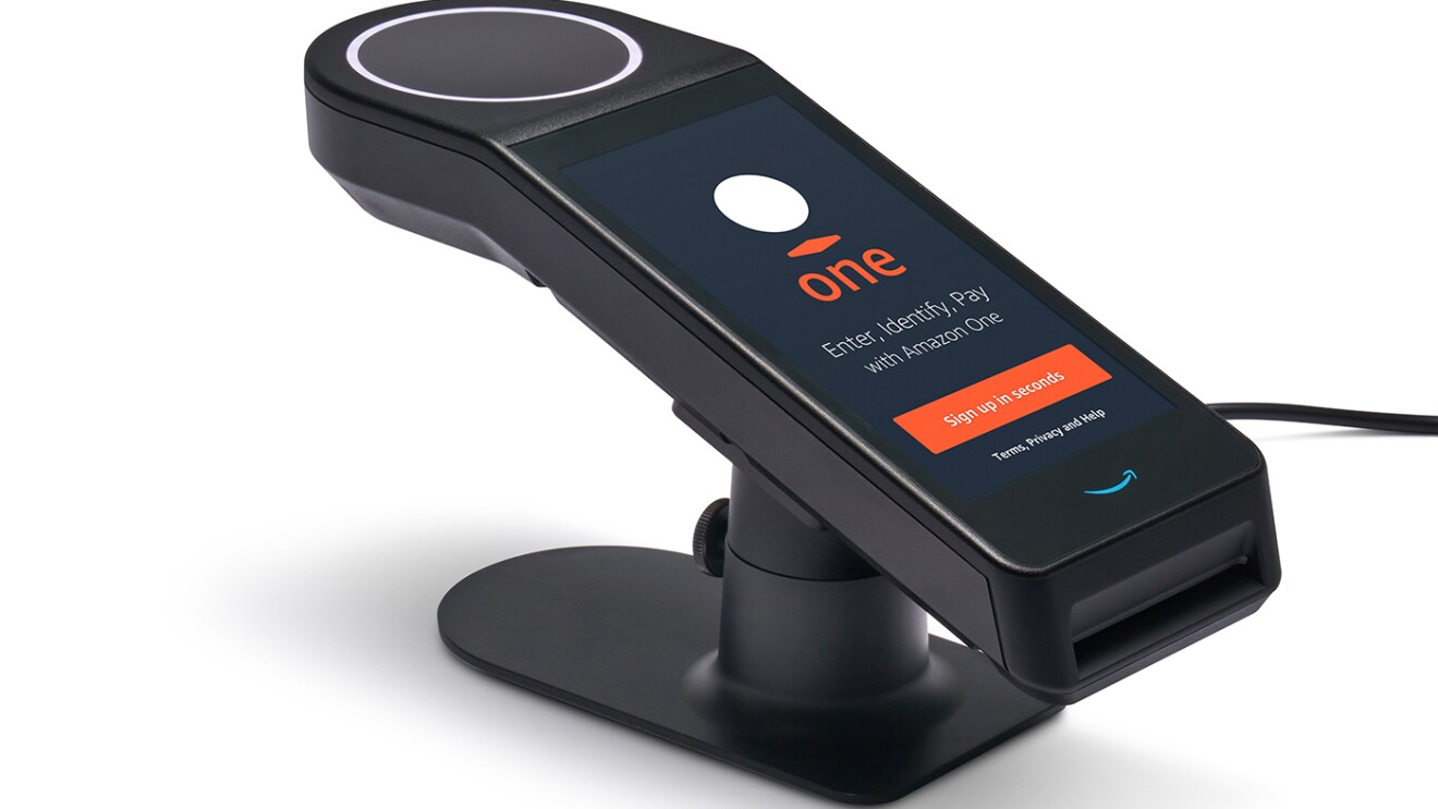 An Amazon One device. Text says "Enter, identify, pay with Amazon One. Sign up in seconds.