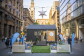 A tiny house set up in a city street for display.