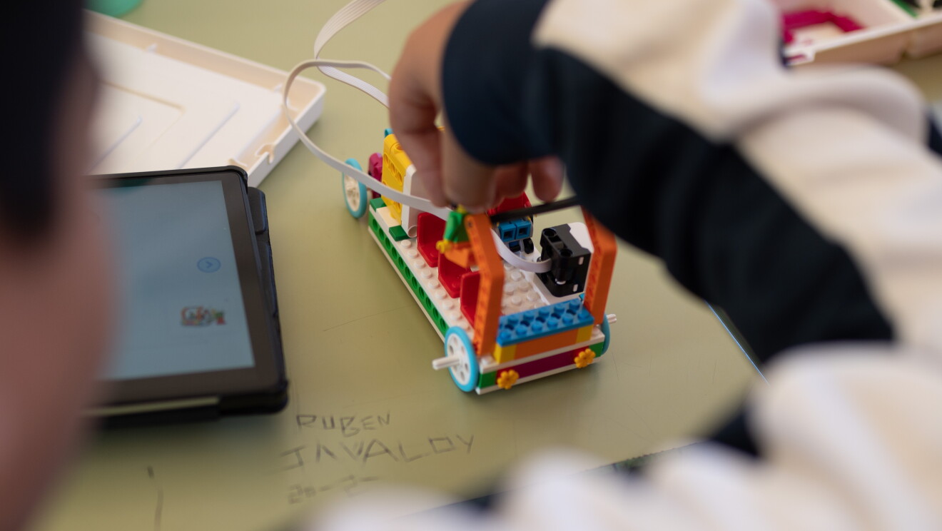Robot creado con Legos Education Spike Essential. Tiene dos ojos con dos patas y unas palancas como si fuera un toro. 