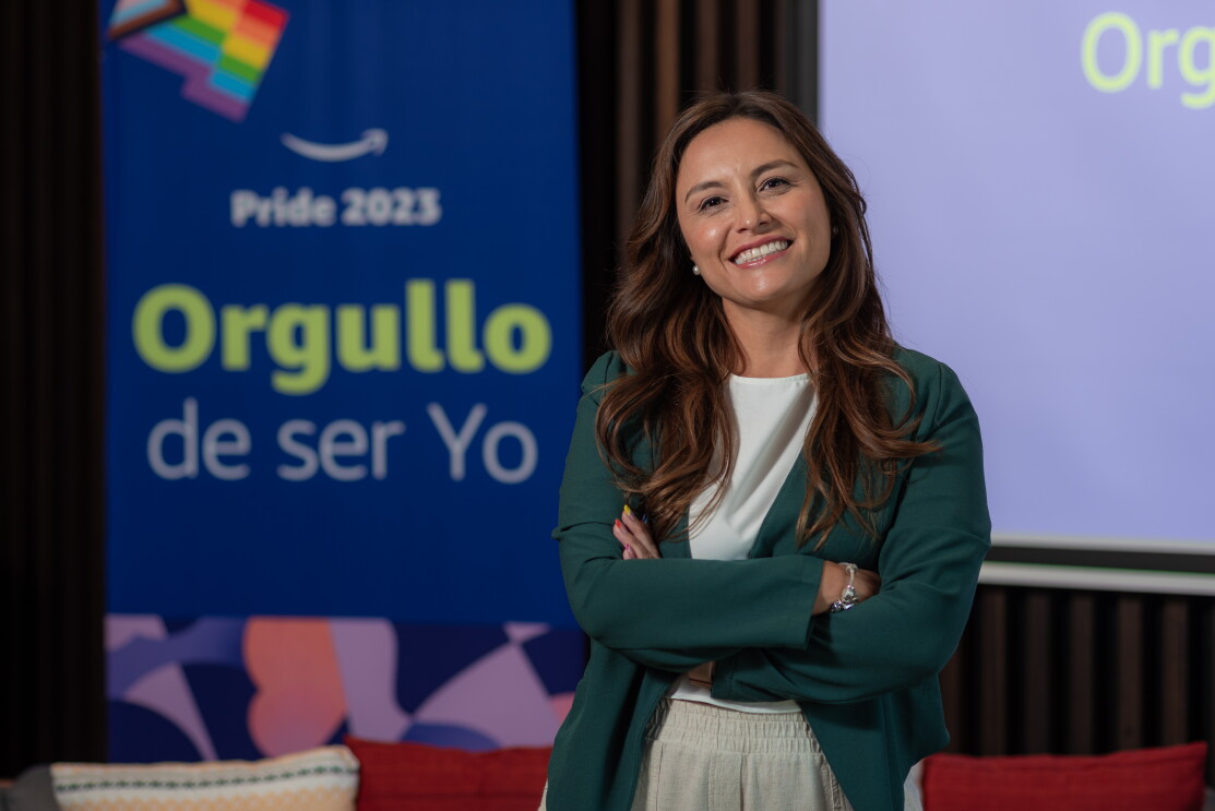 Montserrat Camarillo posando a cámara delante de los carteles de la campaña Orgullo de ser yo. 