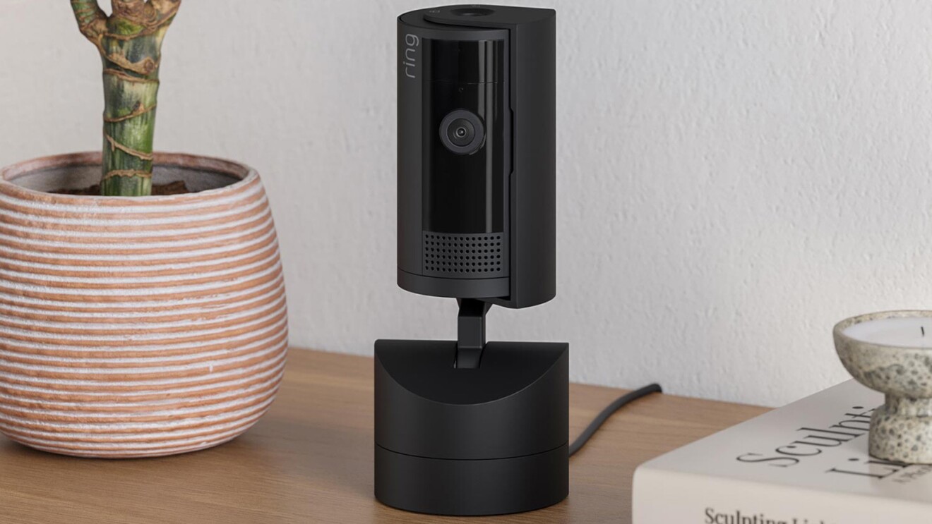 Ring security camera on desk next to potted plant and book
