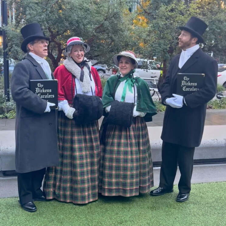 A photo of four carolers singing in South Lake Union on Amazon's campus.