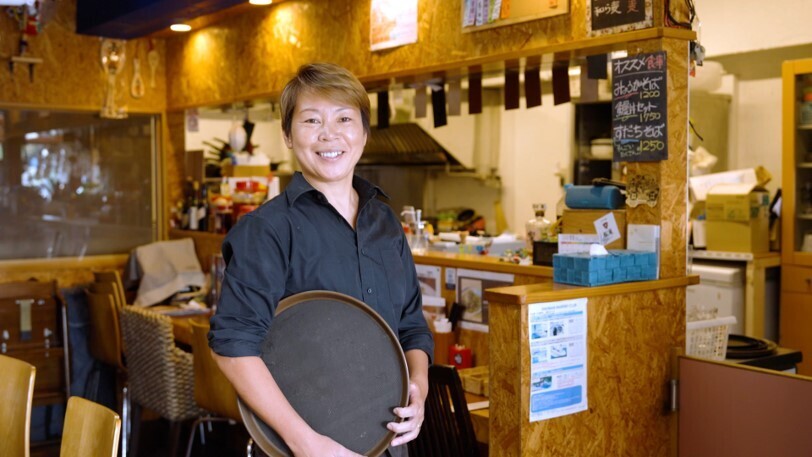 飲食店の中で、お盆を持っている女性