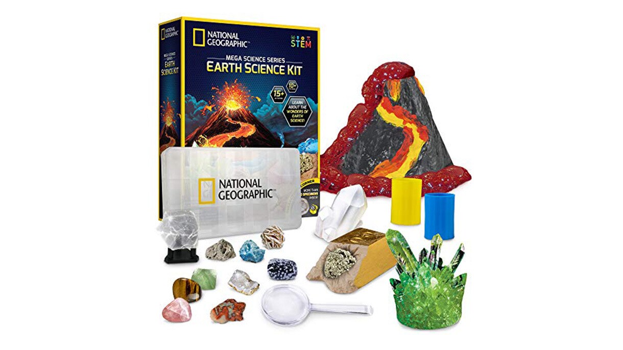 An image of a science kit with a volcano, a magnifying glass, crystals, and other accessories for science experiments.