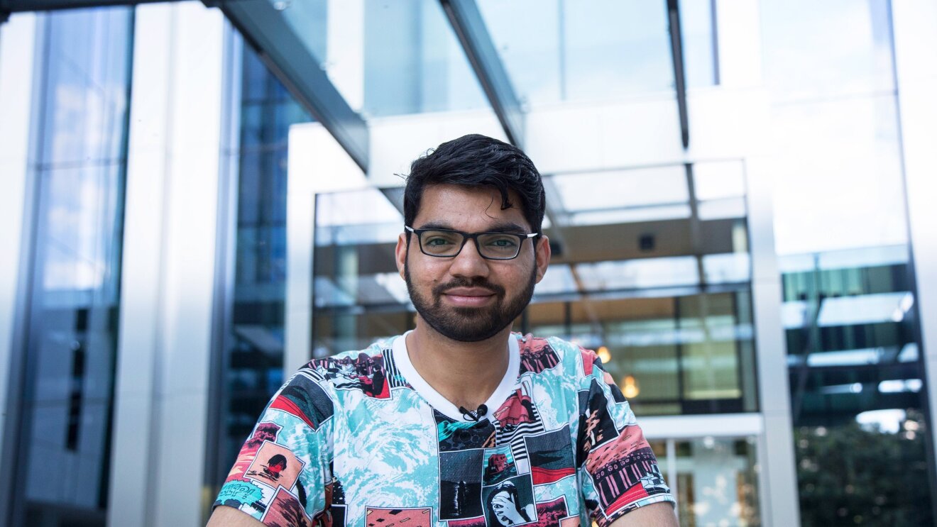 Siddhesh Krishnan, Learning & Development Associate ad Amazon, sorride in posa davanti all'ingresso degli uffici Corporate Amazon di Milano.