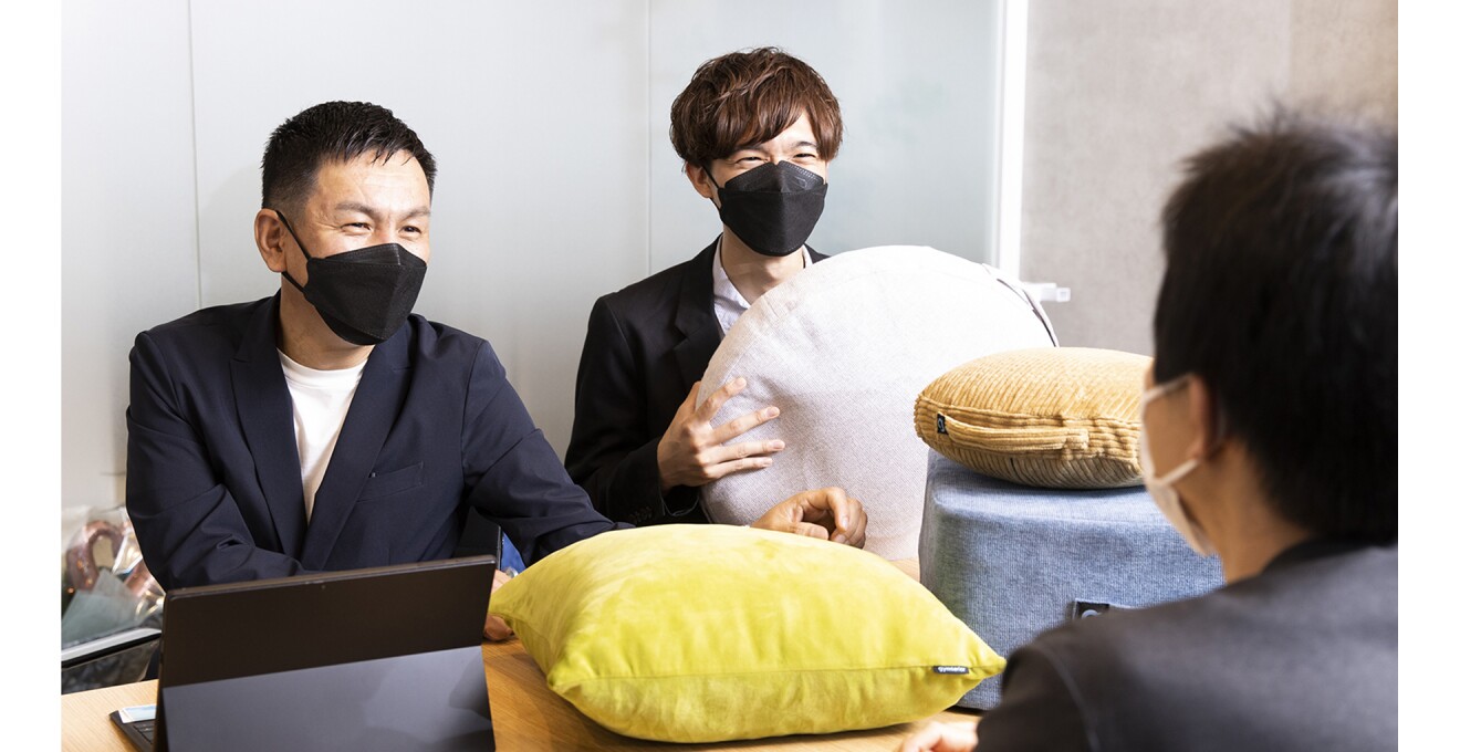 商品を手に話し合いをする山田さん達の写真