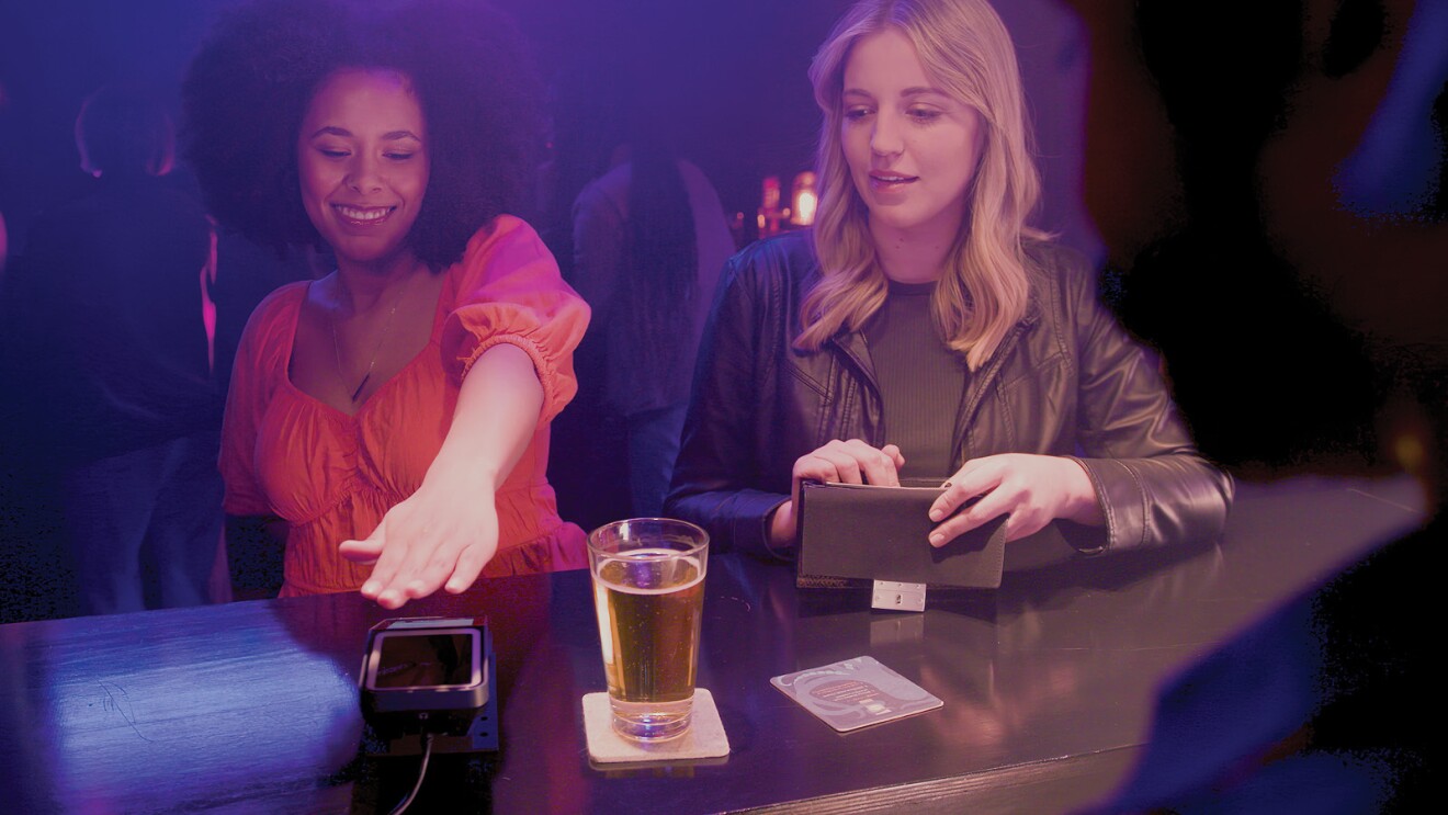 A photo of a customer paying for a beer at a bar using Amazon One.