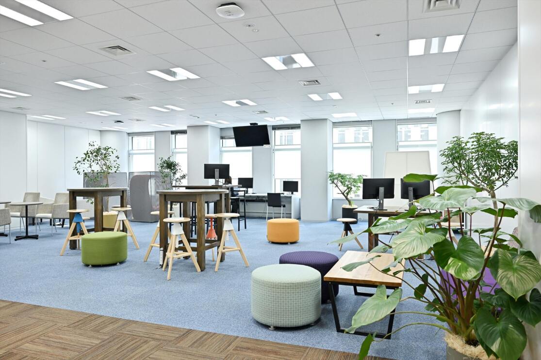 広い空間には6つのカラフルな丸いソファが置かれている。数台のテーブル、モニター椅子などが置かれている。