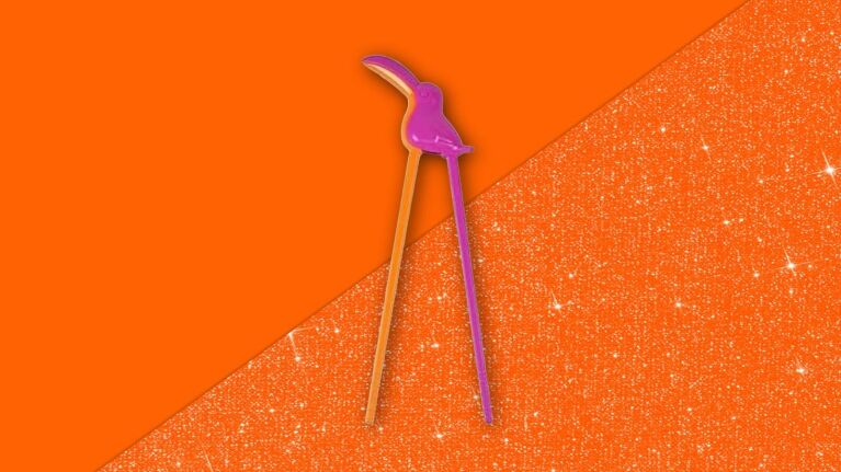 Purple flamingo-shaped chopsticks on vibrant orange glittery background