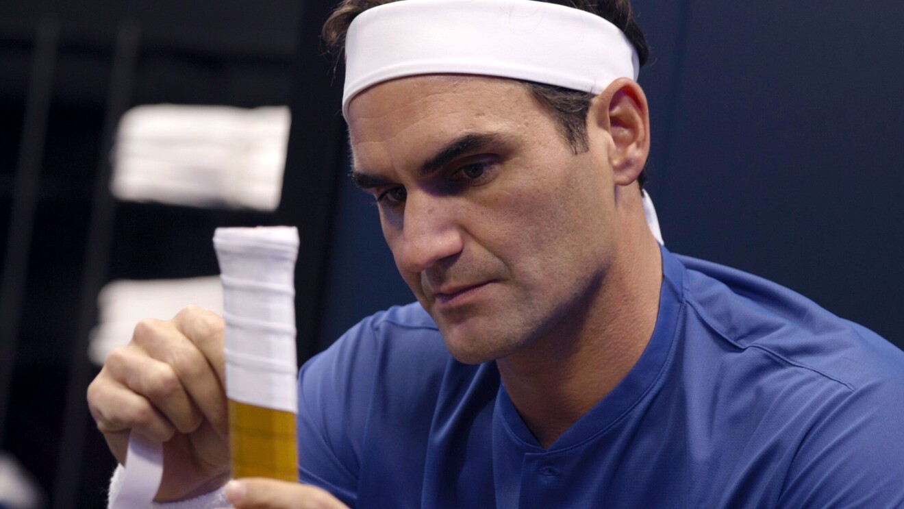 A tennis star wearing a headband and holding the end of a tennis racket