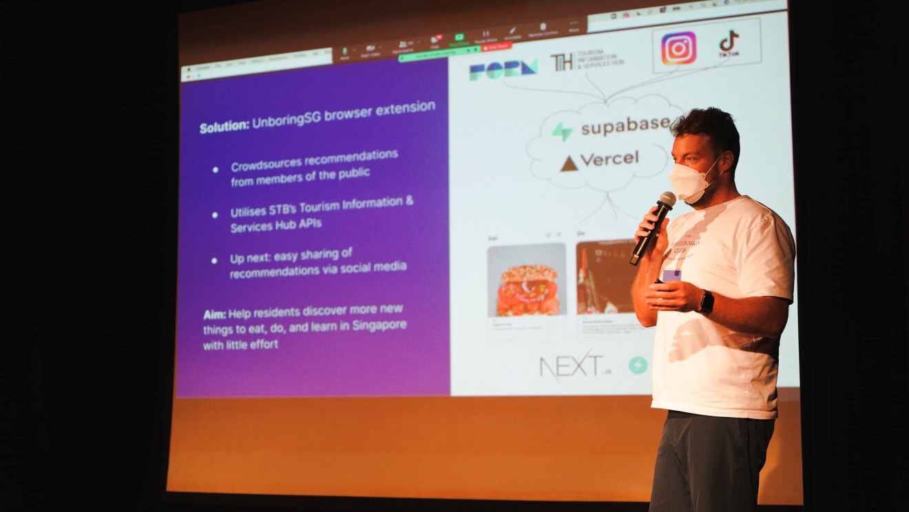 A man in dark shorts and a white shirt presenting.