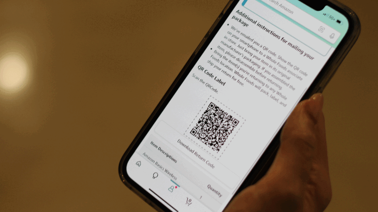 An image of a hand holding a phone. On the phone is a block of text providing instructions to make an Amazon return at Whole Foods Market along with a QR code to scan when you get to the store.