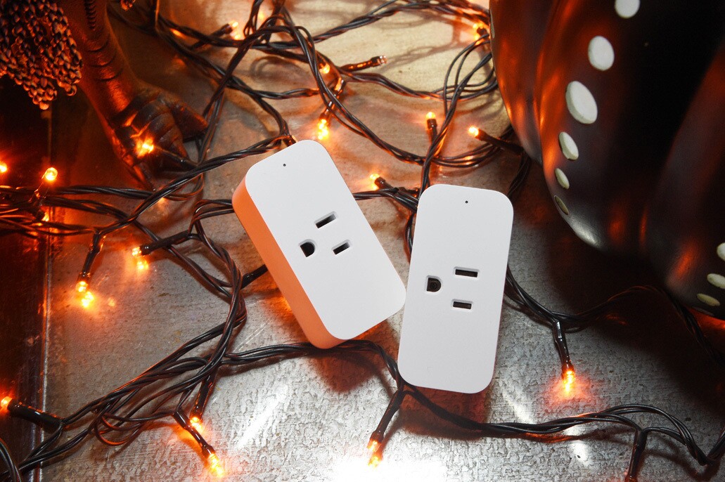 两个电源插座的图片,背景是橙色的假日灯。
