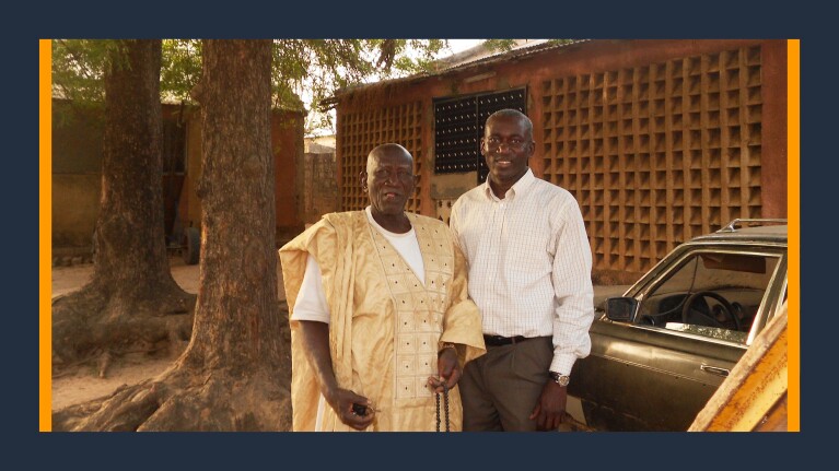 A photo of Alioune Thiam, senior systems engineer at AWS standing next to his father.