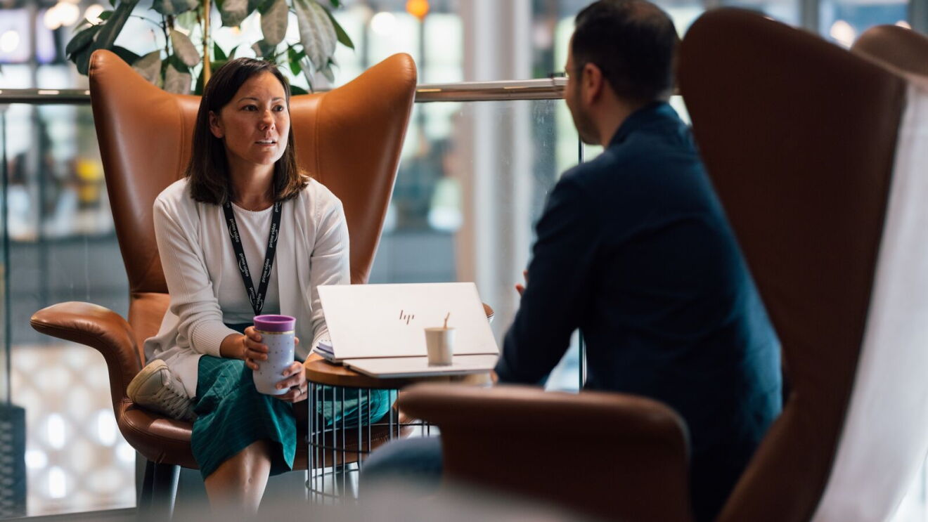 A woman and a man talking while sitting in chairs.