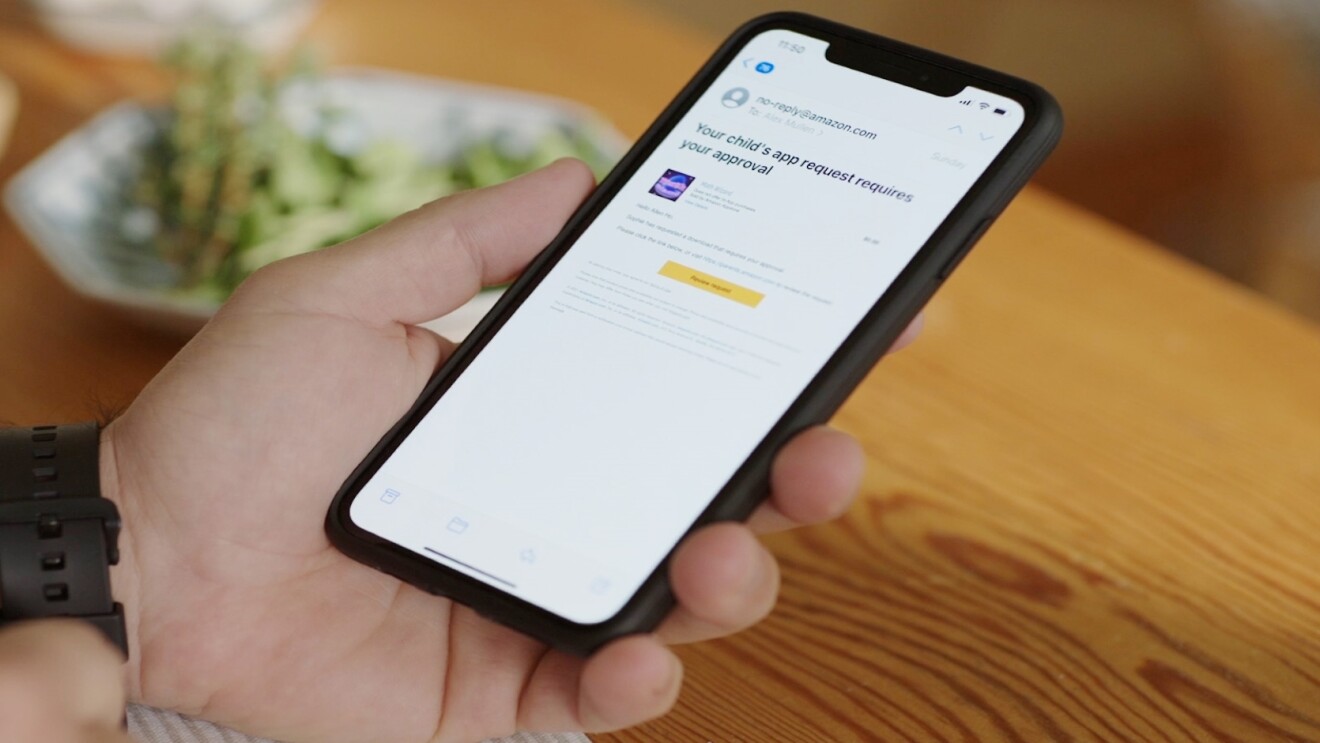 手握一部手机,屏幕显示正在审批孩子的应用程序请求