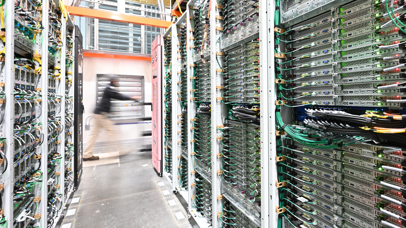 A data center technician pushing a cart inside an Amazon data center.