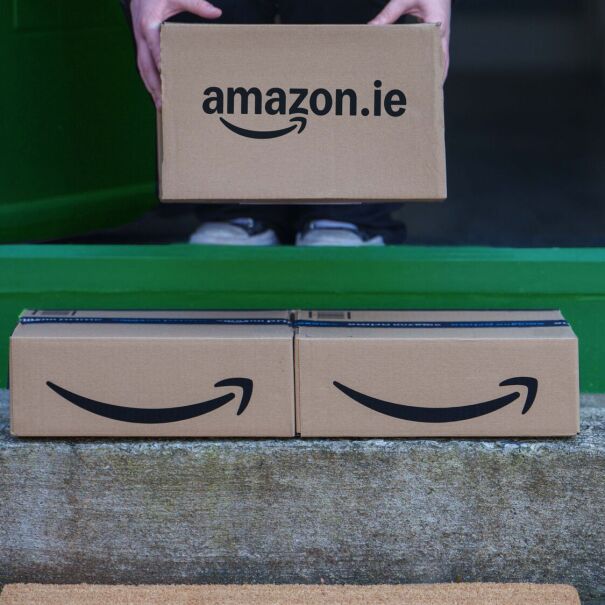 Hands holding Amazon.ie box above doorway