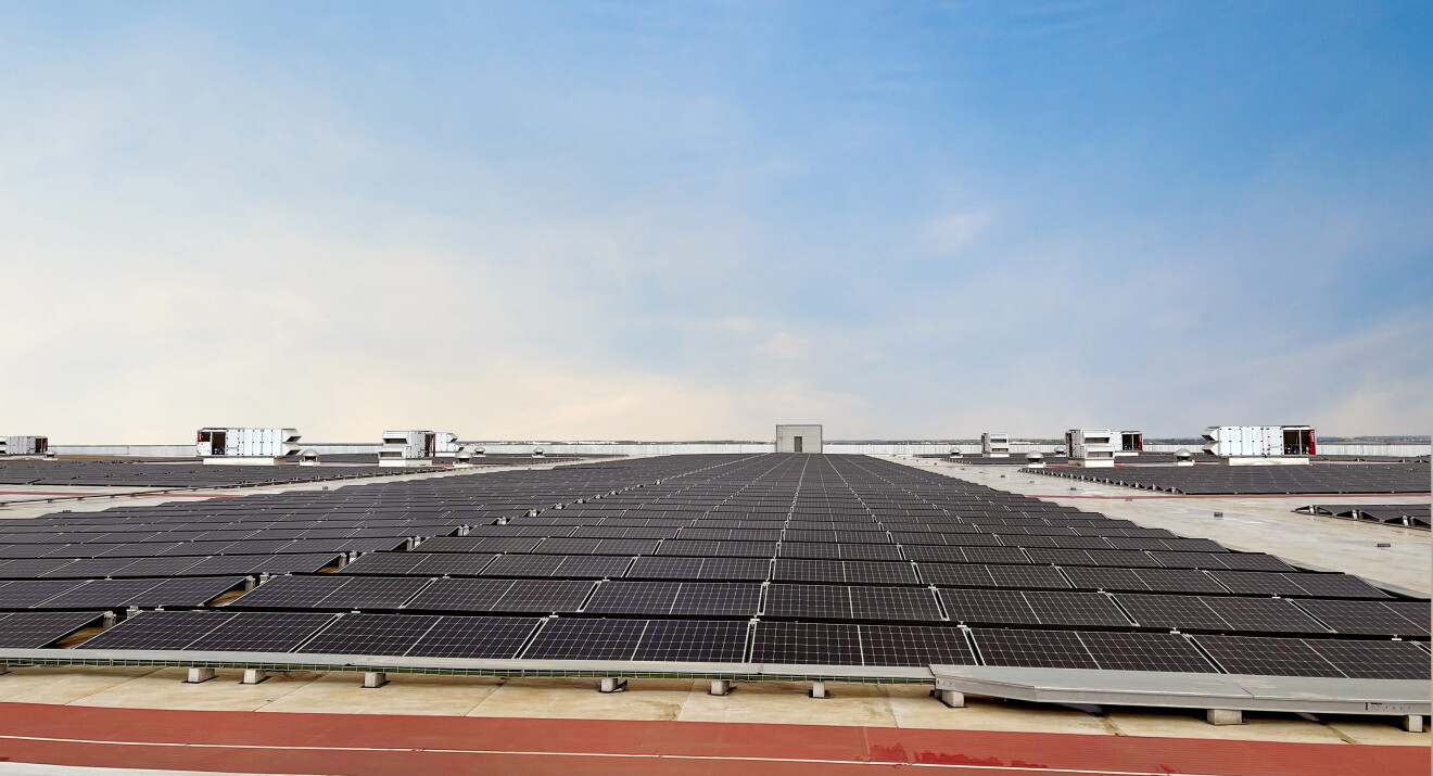 Techo solar de Amazon en el centro logístico de Dos Hermanas SVQ1. En la imagen se ve un techo con placas solares de color negro y la instalación metálica que la rodea. La mitad de la foto es un cielo azul. 
