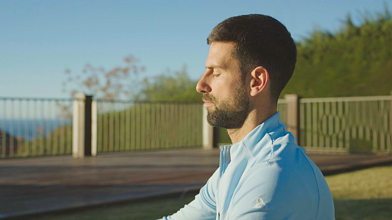 Novak Djokovic meditating in the sunshine