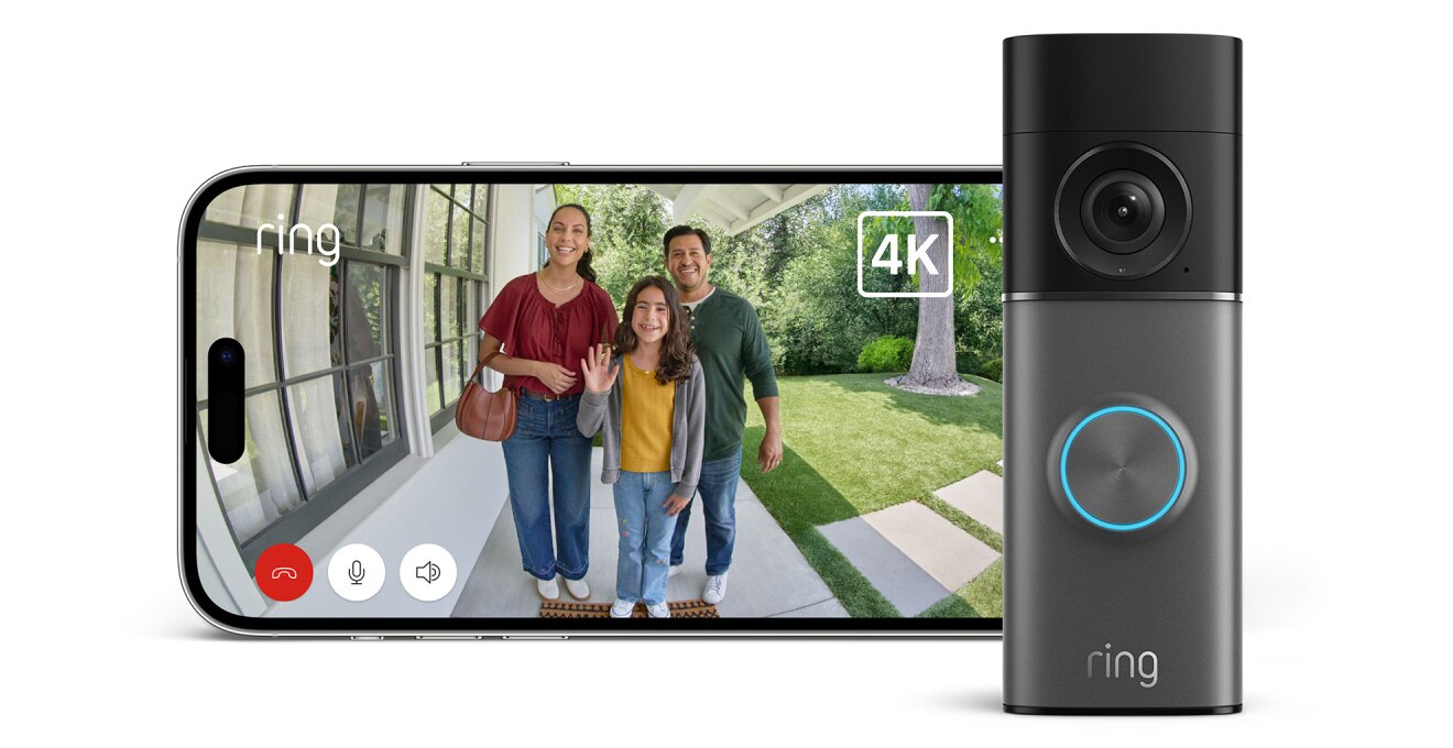 玄関先の映像を表示する横長ディスプレイ、右側にドアベル。画面には白い建物の玄関ポーチと芝生の庭、3人の笑顔の人物が映っている。ドアベル上部は黒でカメラを搭載、グレーの下部のリング外周が青く光る。