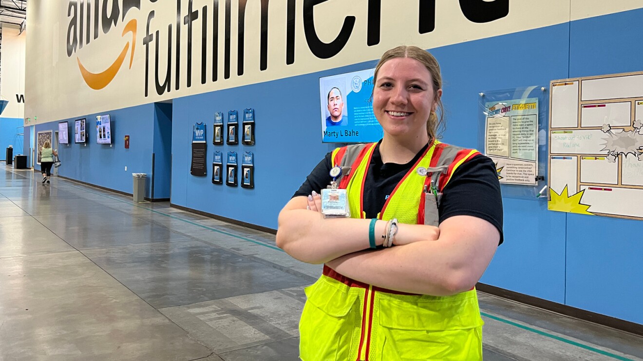 closeup shot of haileigh johnson an area manager at amazon. shes smiling while crossing her arms and wearing a yellow safety vest