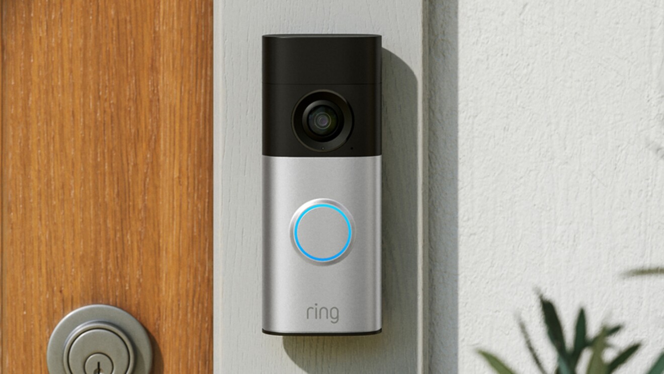 Ring Doorbell Plus Hero set up on a doorframe outside on a sunny day.