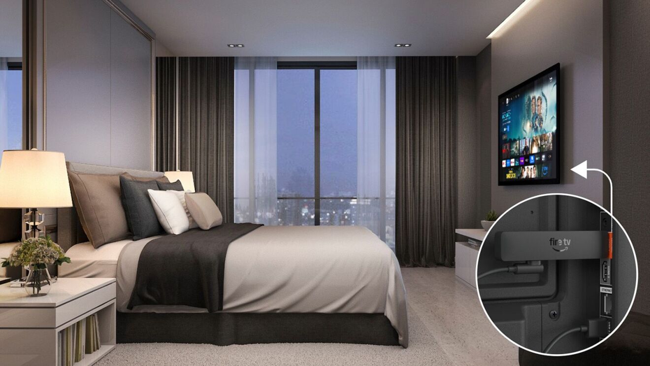 A bedroom with a mounted TV showing where the Amazon Fire Stick is connected